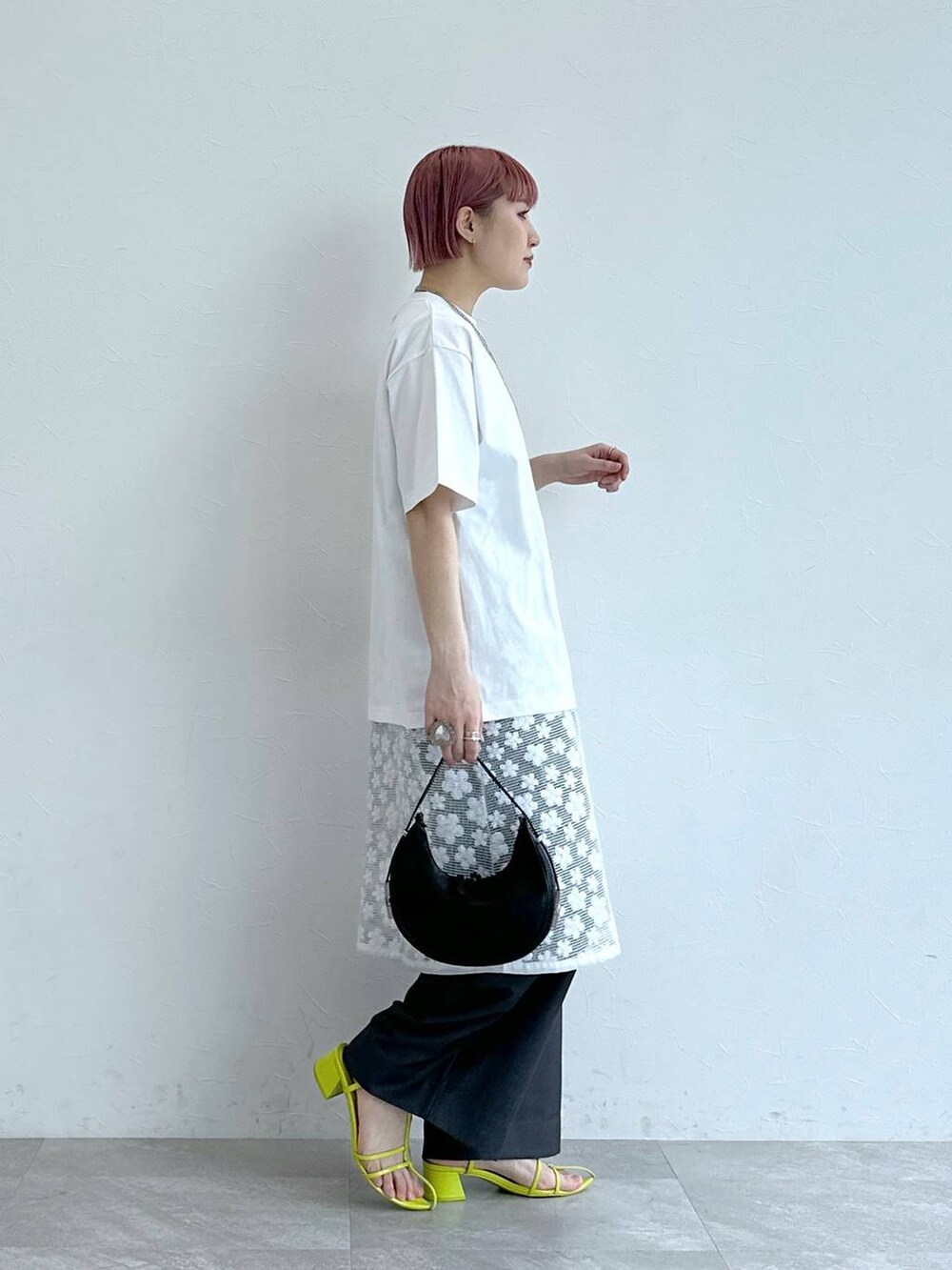 グレー系のスラックス、ホワイト系のワンピース、ホワイト系のTシャツ/カットソーを着用したレディースの春コーディネートの4枚目の写真