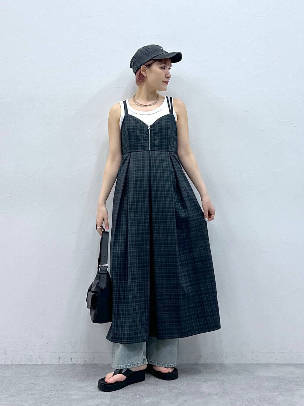 ブルー系のデニムパンツ、グレー系のワンピース、ホワイト系のタンクトップを着用したレディースの春コーディネートの3枚目の写真