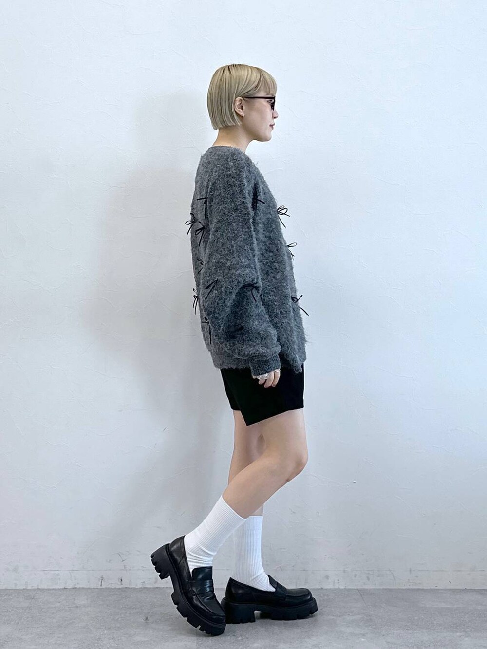 ブラック系のチノパンツ、レッド系のショルダーバッグ、グレー系のニット/セーターを着用したレディースの冬コーディネートの4枚目の写真