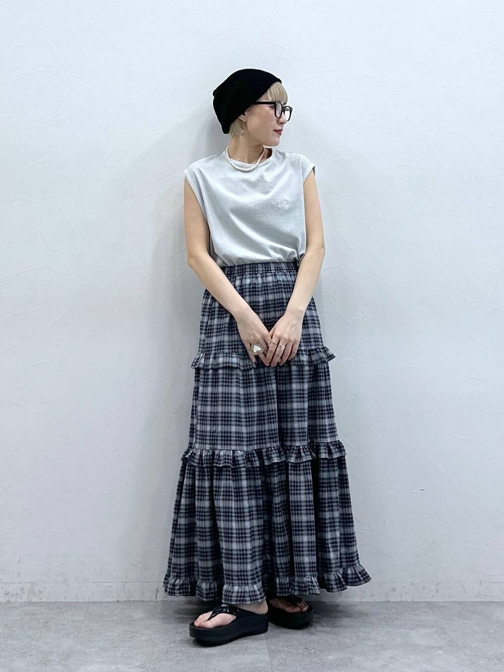 グレー系のTシャツ/カットソー、ブルー系のスカート、ブラック系のサンダルを着用したレディースの夏コーディネートの2枚目の写真
