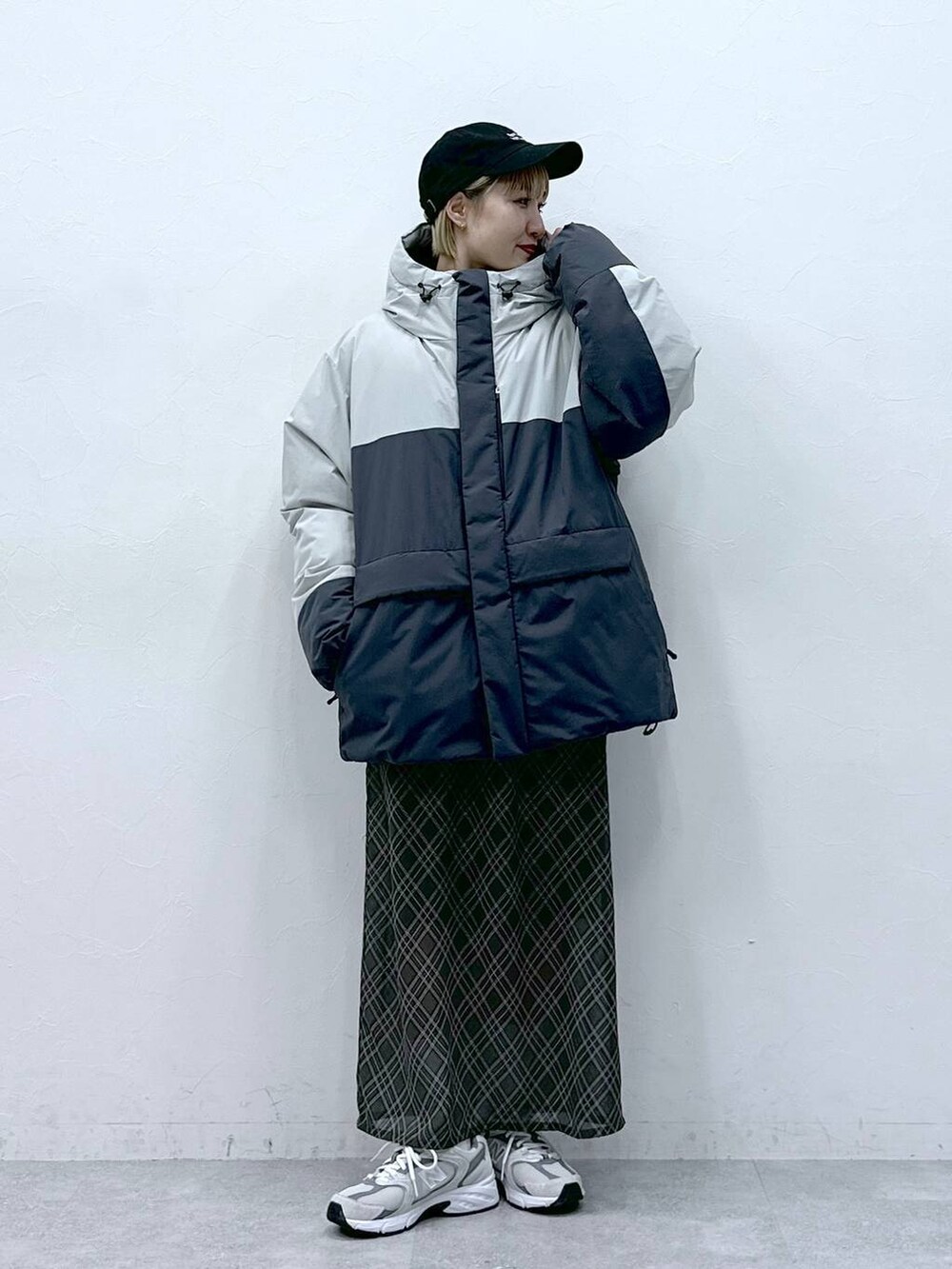 グレー系のダウンジャケット/コート、ブラック系のキャップを着用したレディースの冬コーディネートの6枚目の写真