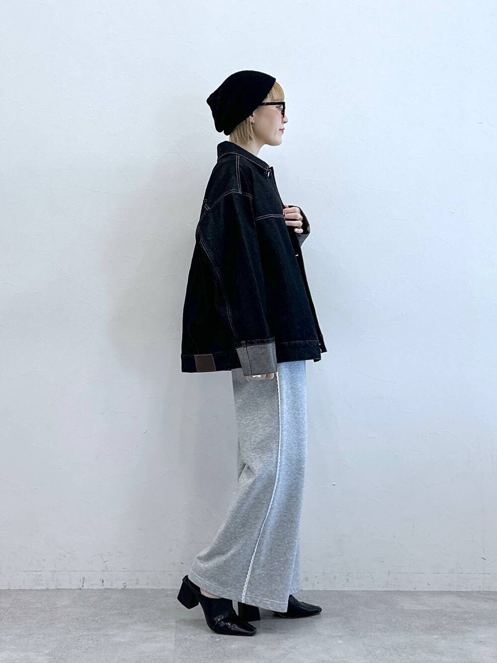 ブラック系のデニムジャケット、グレー系のスウェットパンツ、ブラック系のニットキャップ/ビーニーを着用したレディースの夏コーディネートの5枚目の写真
