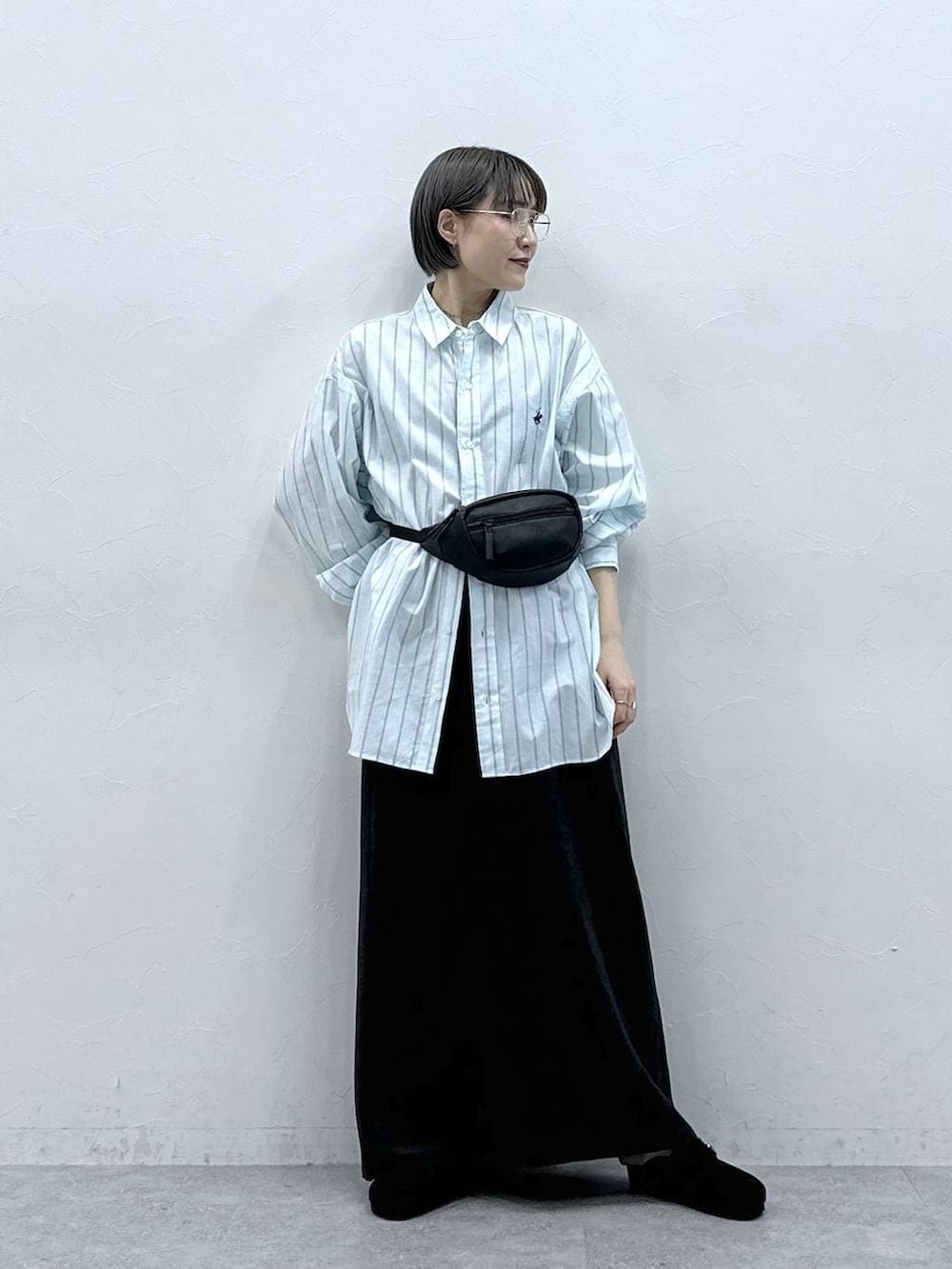 グリーン系のシャツ/ブラウス、ブラック系のボディバッグ/ウエストポーチ、ブラック系のモカシン/デッキシューズを着用したレディースの春コーディネートの3枚目の写真