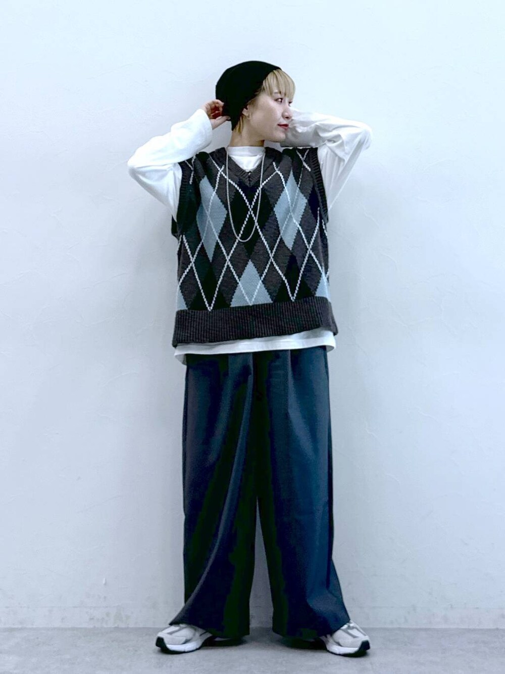 ホワイト系のTシャツ/カットソー、グレー系のスラックス、グレー系のベストを着用したレディースの冬コーディネートの3枚目の写真