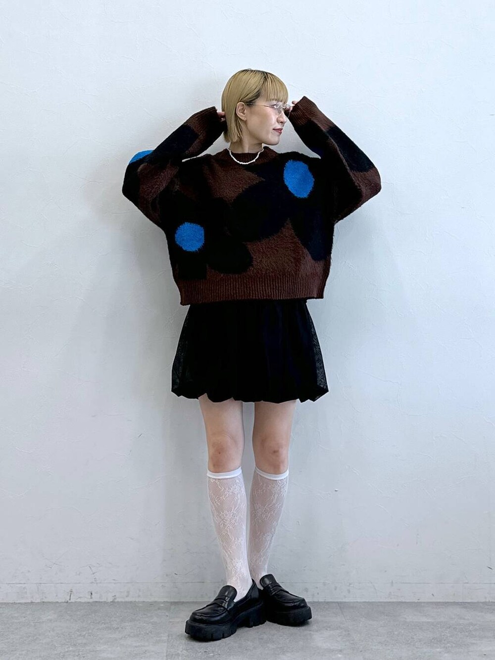 ブラック系のローファー、ブラック系のスカート、ブラウン系のニット/セーターを着用したレディースの夏コーディネートの3枚目の写真