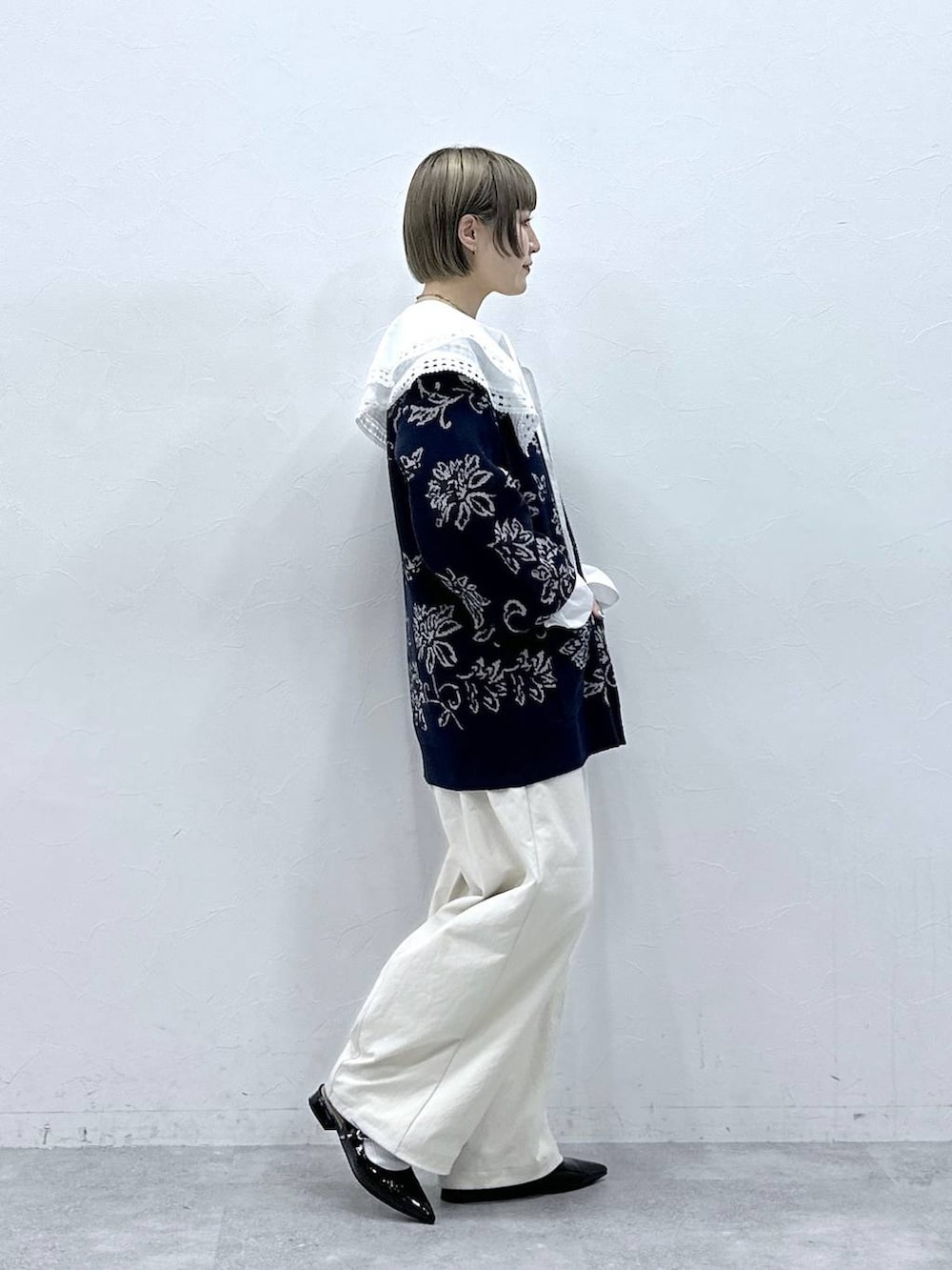 ホワイト系のチノパンツ、ホワイト系のシャツ/ブラウス、ブルー系のニット/セーターを着用したレディースの冬コーディネートの5枚目の写真