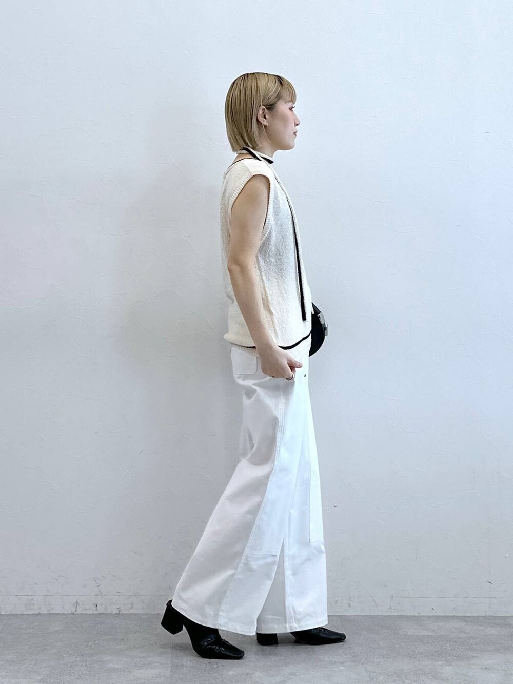 ホワイト系のニット/セーター、ホワイト系のチノパンツを着用したレディースの夏コーディネートの5枚目の写真