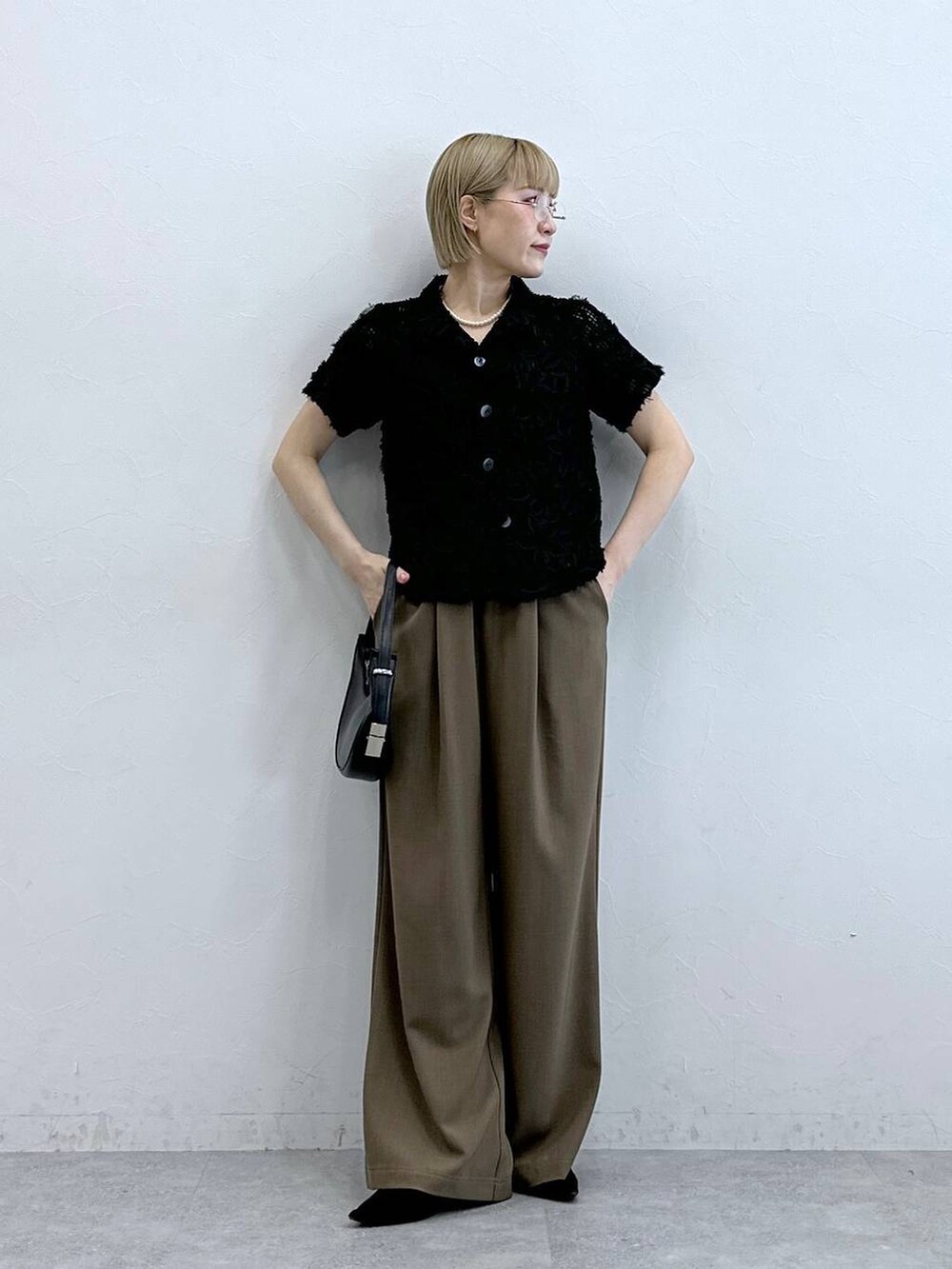 ブラック系のシャツ/ブラウス、ブラウン系のスラックスを着用したレディースの夏コーディネートの4枚目の写真