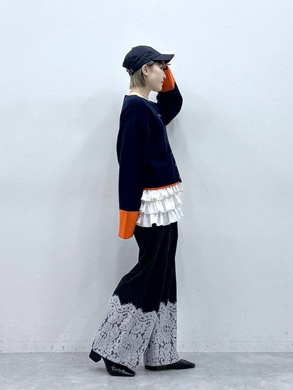 ホワイト系のキャミソール、ブルー系のカーディガン/ボレロ、ブラック系のデニムパンツを着用したレディースの冬コーディネートの5枚目の写真