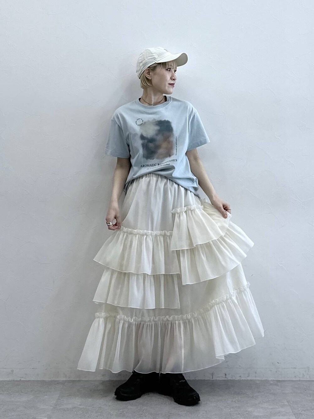 ブルー系のTシャツ/カットソー、ホワイト系のスカート、ホワイト系のキャップを着用したレディースの春コーディネートの4枚目の写真