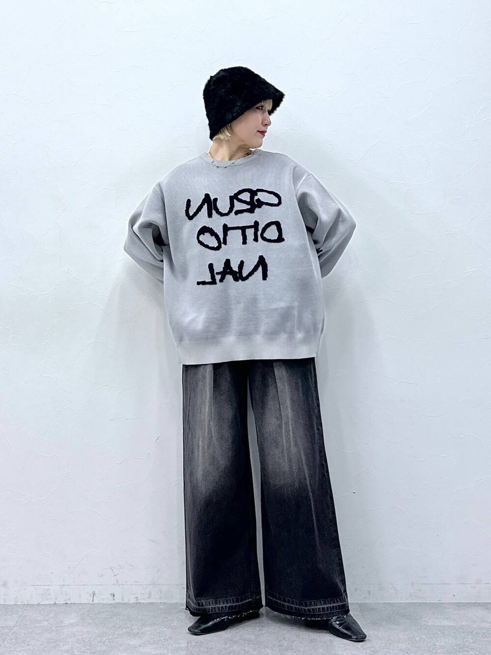 ブラック系のデニムパンツ、グレー系のニット/セーターを着用したレディースの秋コーディネートの2枚目の写真