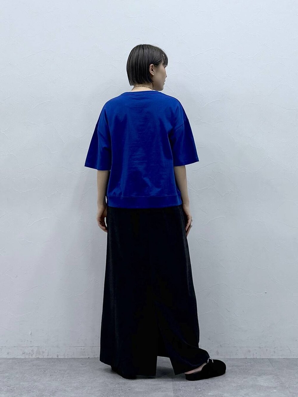 ブルー系のTシャツ/カットソー、ブラック系のモカシン/デッキシューズ、ブラック系のスカートを着用したレディースの春コーディネートの5枚目の写真