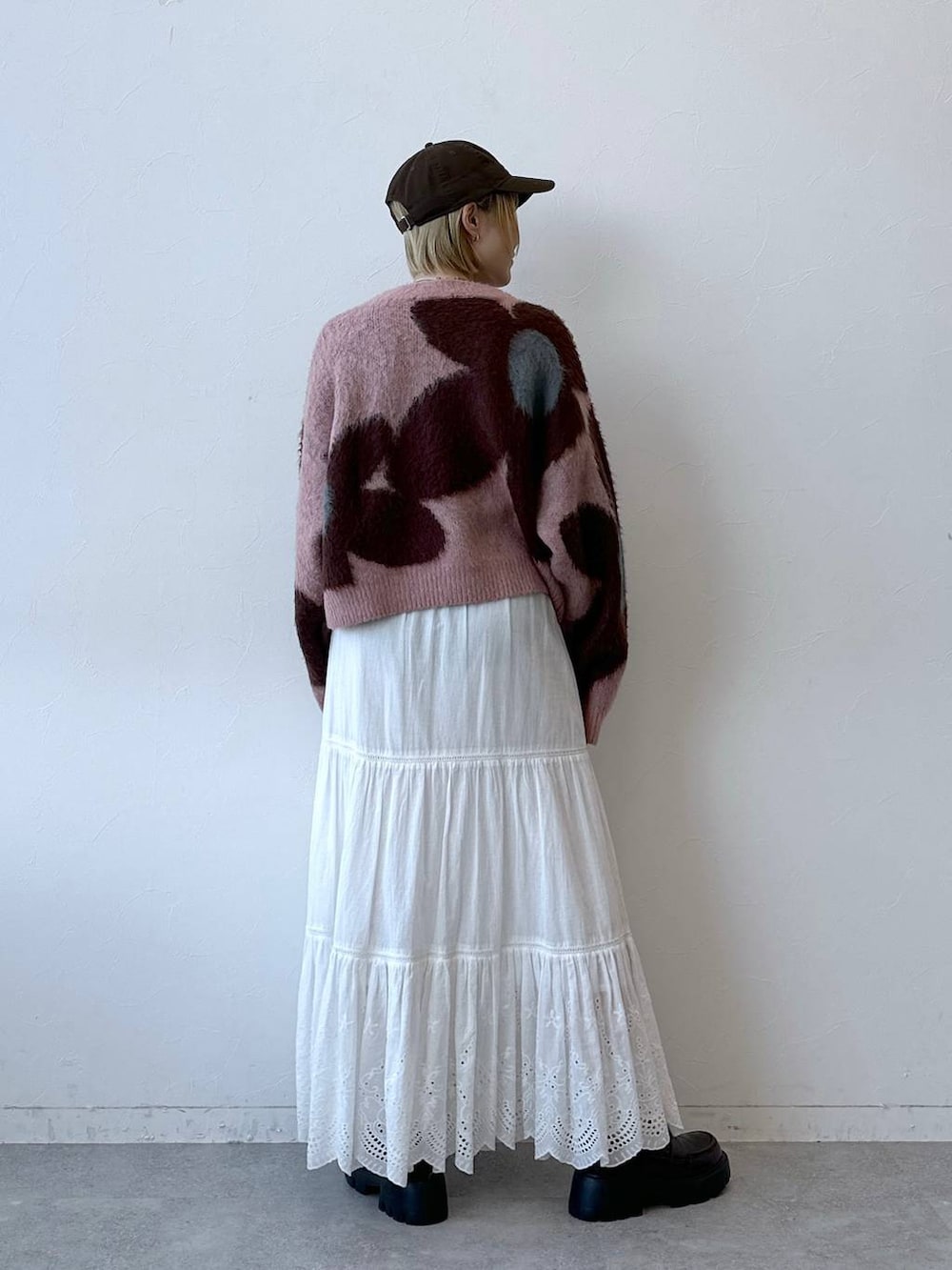ブラック系のローファー、ピンク系のニット/セーター、ホワイト系のスカートを着用したレディースの秋コーディネートの6枚目の写真