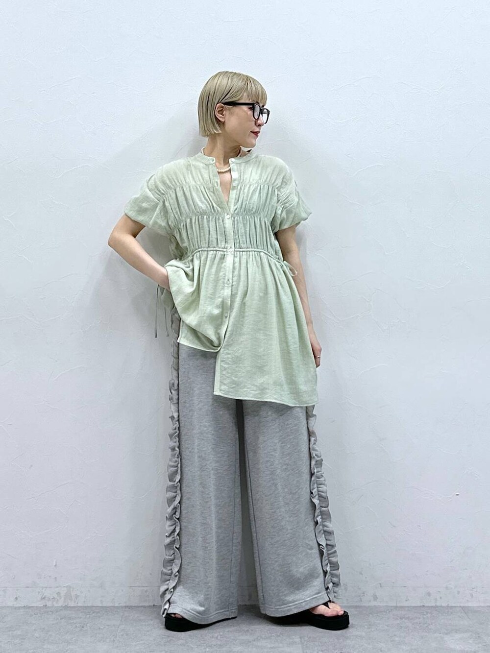 グレー系のスウェットパンツ、グリーン系のシャツ/ブラウス、ブラック系のサンダルを着用したレディースの夏コーディネートの3枚目の写真