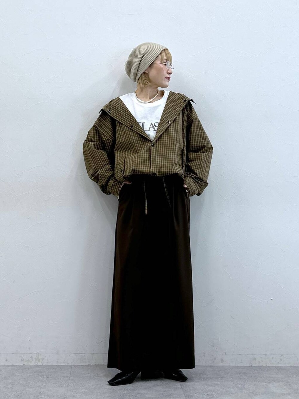 イエロー系のシャツ/ブラウス、ベージュ系のニットキャップ/ビーニーを着用したレディースの夏コーディネートの2枚目の写真