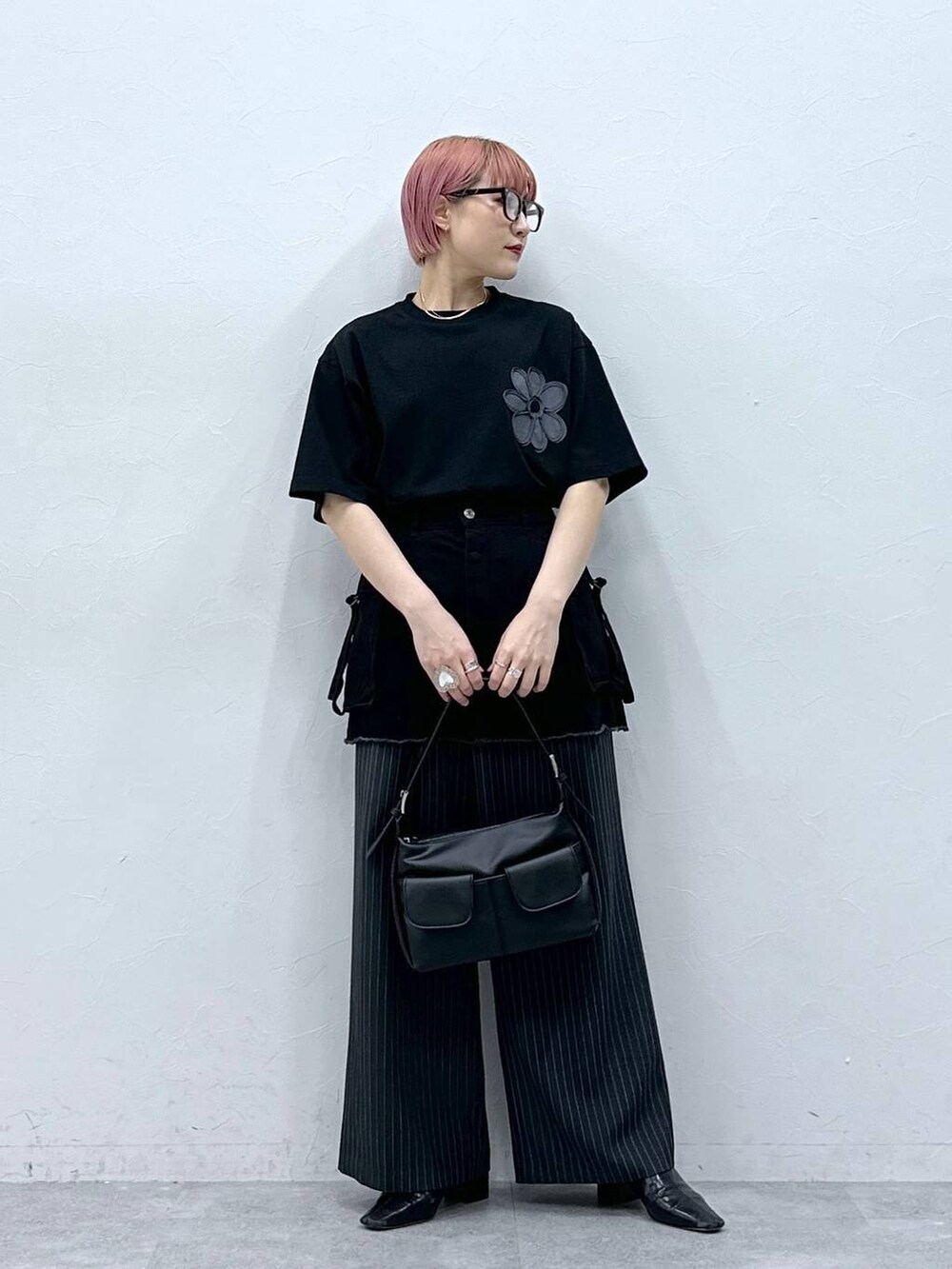 グレー系のスラックス、ブラック系のTシャツ/カットソー、ブラック系のスカートを着用したレディースの春コーディネートの2枚目の写真