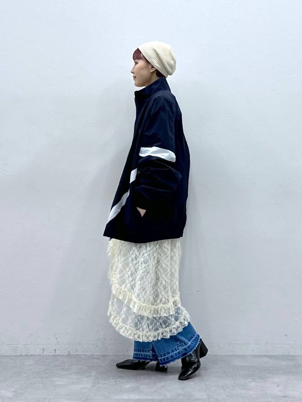 ブルー系のブルゾン、ブルー系のデニムパンツ、ホワイト系のスカートを着用したレディースの春コーディネートの6枚目の写真