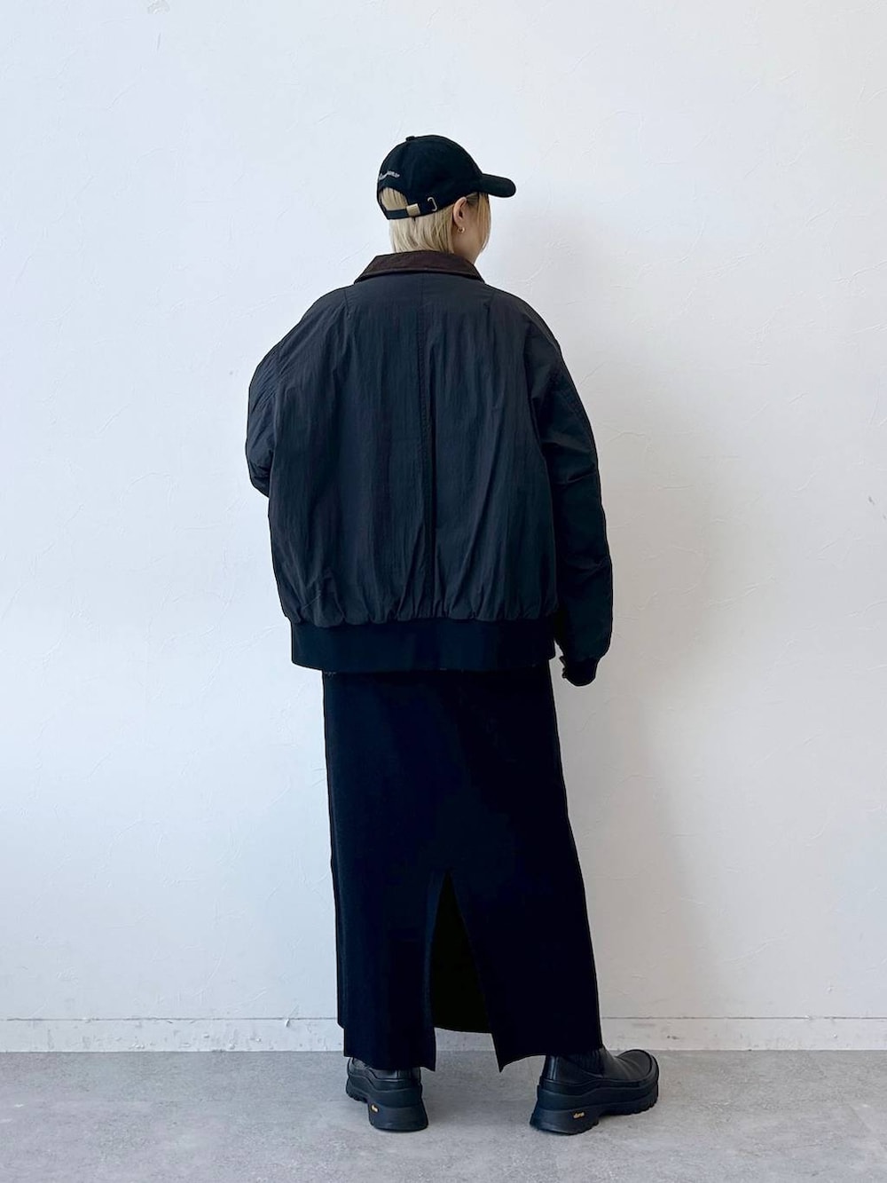 ブラック系のブルゾン、グレー系のニット/セーター、ブラック系のスカートを着用したレディースの冬コーディネートの5枚目の写真