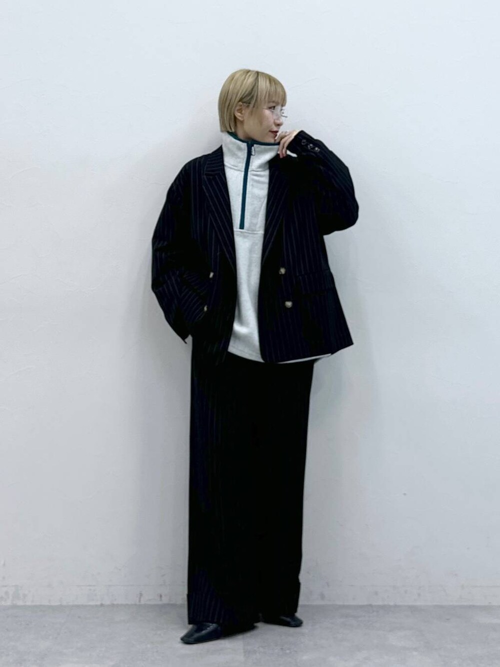 ホワイト系のスウェット、ブラック系のスラックス、ブラック系のテーラードジャケットを着用したレディースの秋コーディネートの3枚目の写真