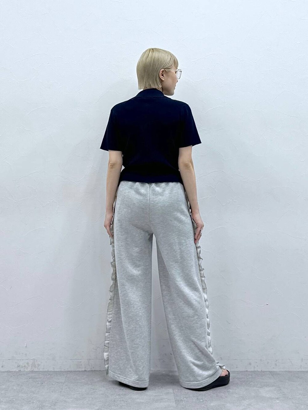 グレー系のスウェットパンツ、ブルー系のニット/セーター、ブラック系のサンダルを着用したレディースの夏コーディネートの6枚目の写真