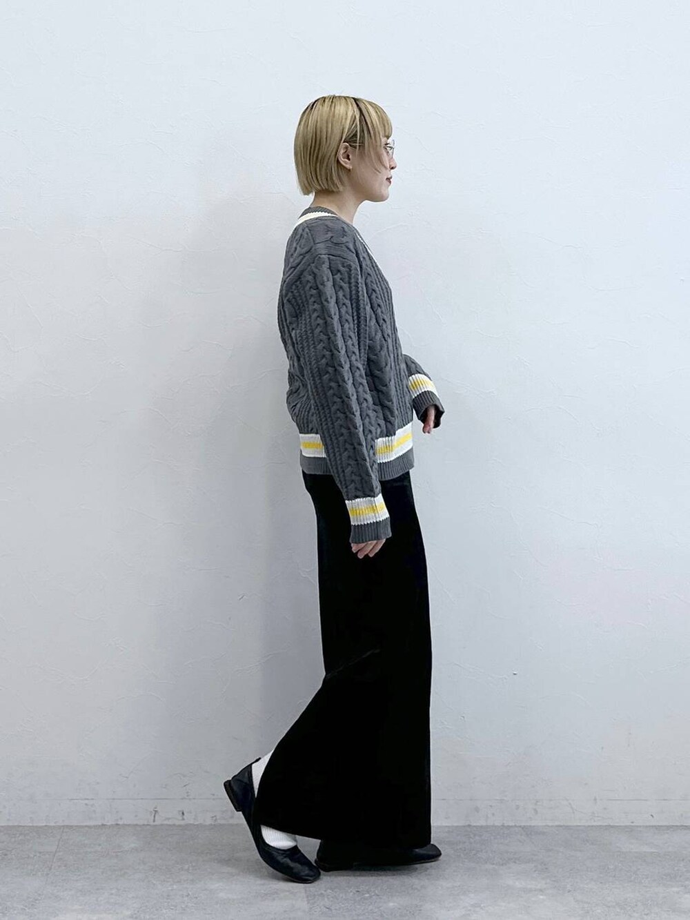 グレー系のニット/セーター、ブラック系のスカートを着用したレディースの秋コーディネートの5枚目の写真