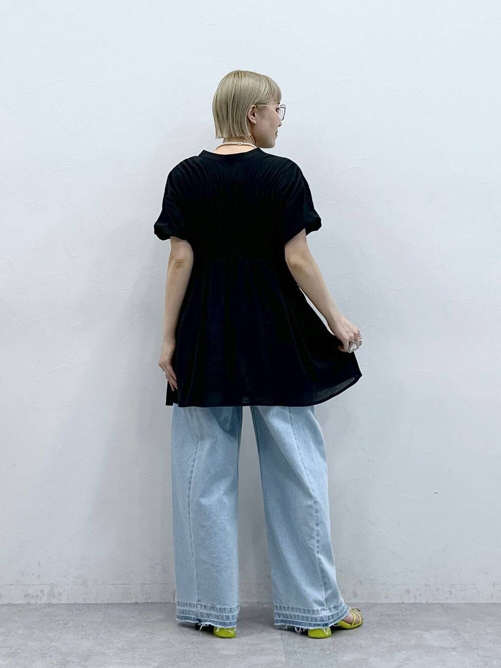 ブルー系のデニムパンツ、ブラック系のシャツ/ブラウス、ブラック系のメガネを着用したレディースの夏コーディネートの6枚目の写真