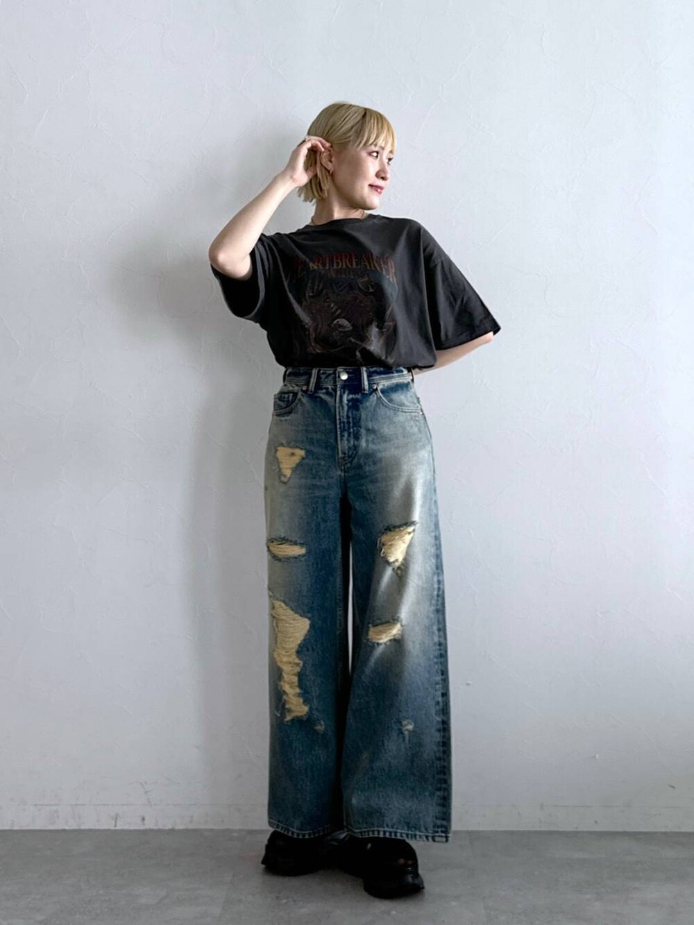 ブラック系のTシャツ/カットソー、ブラック系のサンダル、ブラック系のデニムパンツを着用したレディースの夏コーディネートの3枚目の写真