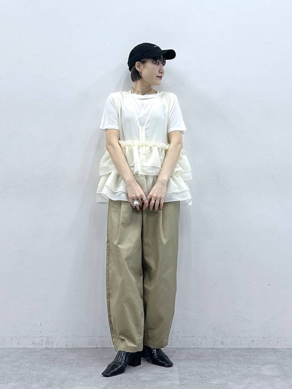 ベージュ系のチノパンツ、ホワイト系のTシャツ/カットソー、ホワイト系のベストを着用したレディースの春コーディネートの3枚目の写真