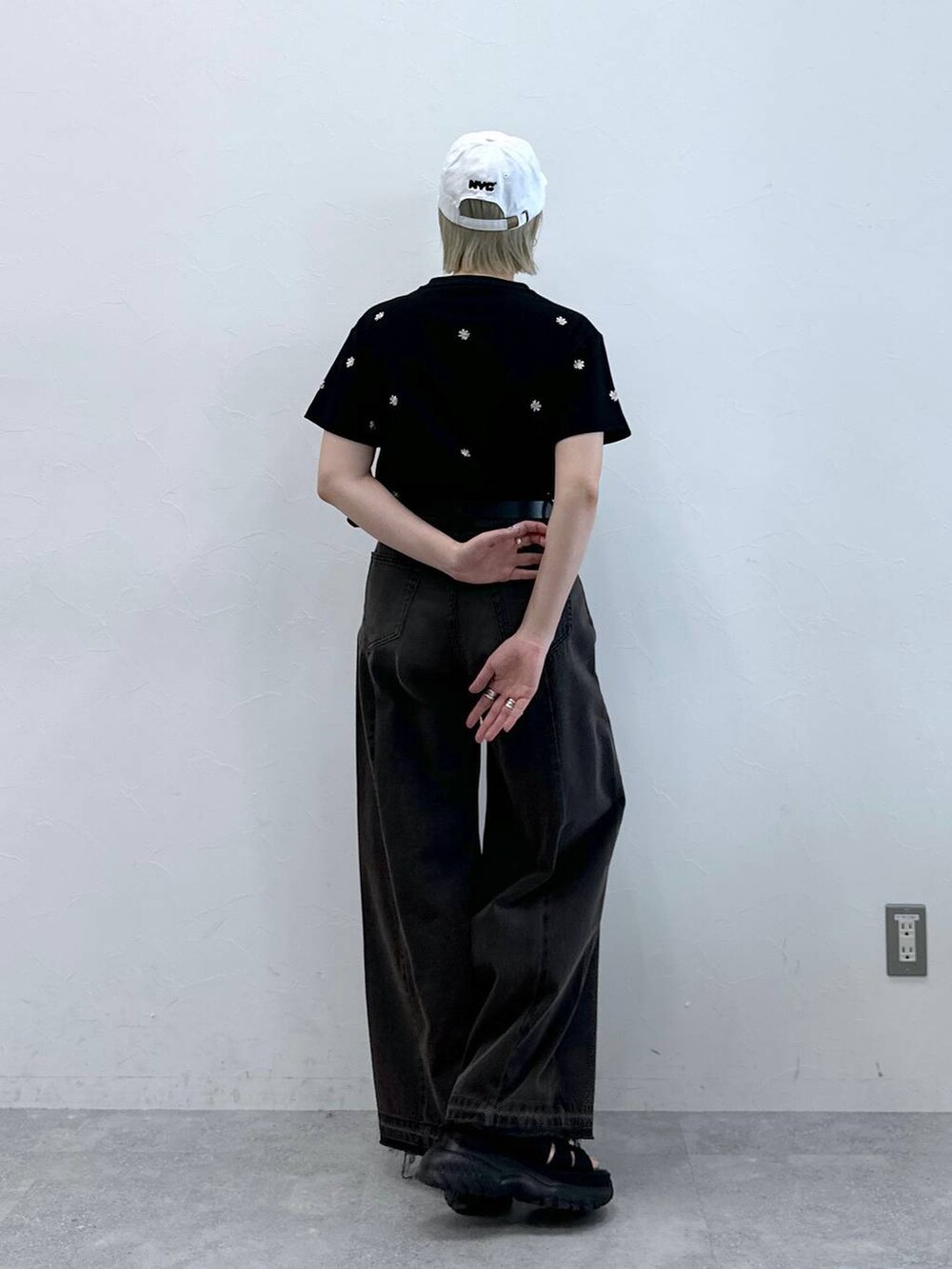 ブラック系のデニムパンツ、ブラック系のサンダル、ブラック系のTシャツ/カットソーを着用したレディースの夏コーディネートの2枚目の写真