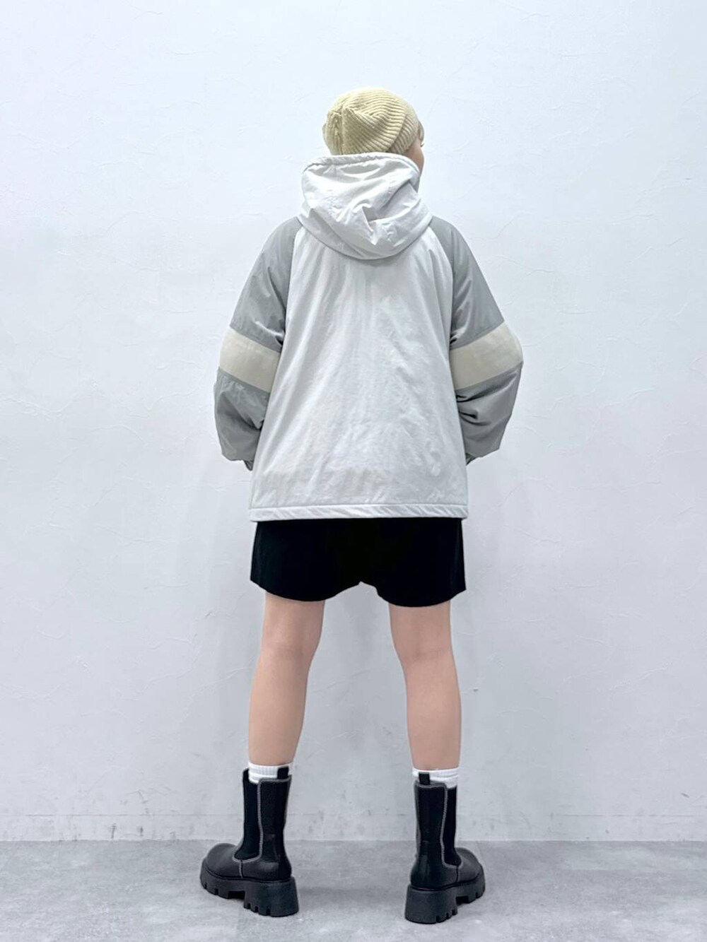 ブラック系のチノパンツ、ブラック系のブーツ、グレー系のダウンジャケット/コートを着用したレディースの秋コーディネートの4枚目の写真