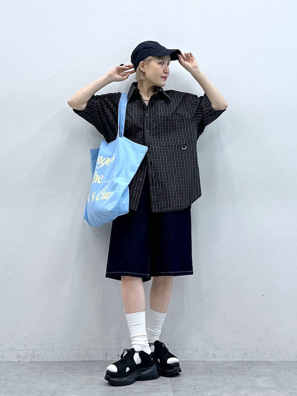 ブラック系のサンダル、ブルー系のデニムパンツ、ピンク系のトートバッグを着用したレディースの夏コーディネートの5枚目の写真