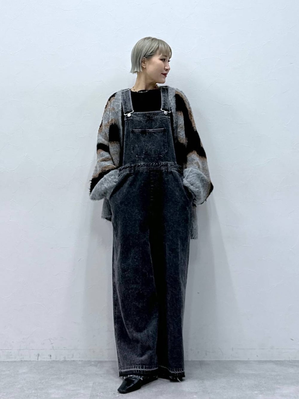 ブラック系のTシャツ/カットソー、ブラック系のカーディガン/ボレロ、ブラック系のサロペット/オーバーオールを着用したレディースの秋コーディネートの6枚目の写真