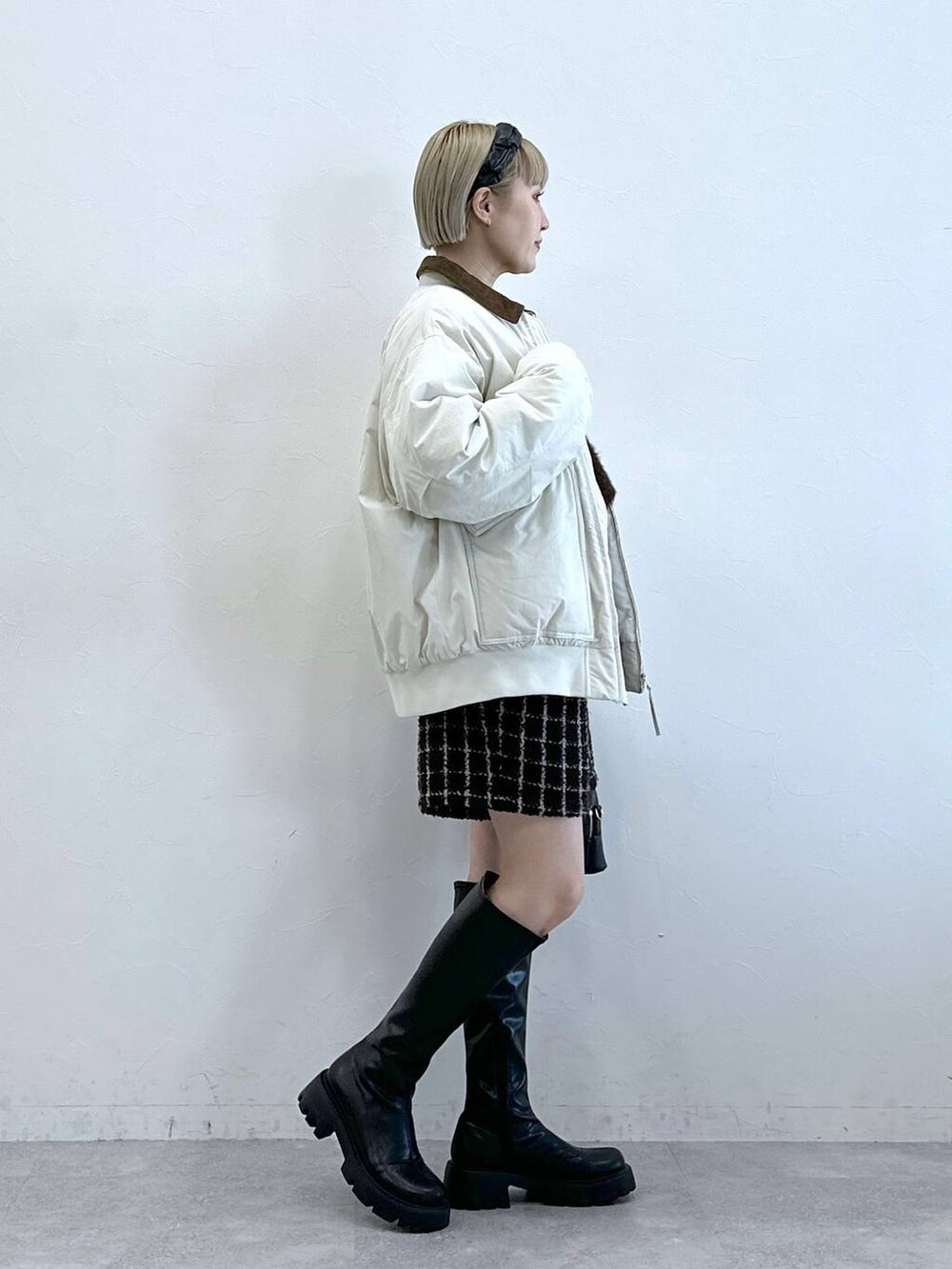 ブラック系のブーツ、ブラウン系のその他パンツ、ホワイト系のブルゾンを着用したレディースの冬コーディネートの3枚目の写真