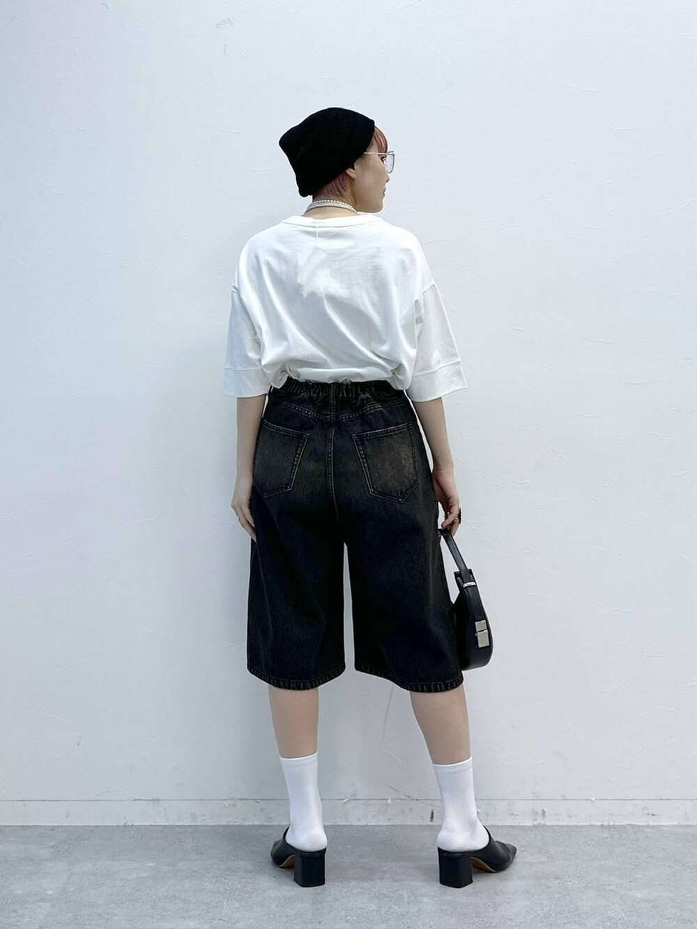 ブラック系のデニムパンツ、ホワイト系のTシャツ/カットソーを着用したレディースの春コーディネートの5枚目の写真
