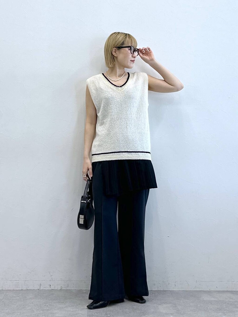 ホワイト系のニット/セーター、その他のスラックス、ブラック系のスカートを着用したレディースの夏コーディネートの3枚目の写真