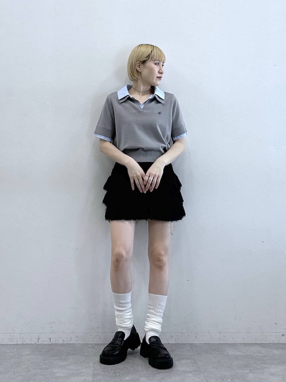 ブラック系のスカート、グレー系のシャツ/ブラウスを着用したレディースの春コーディネートの3枚目の写真