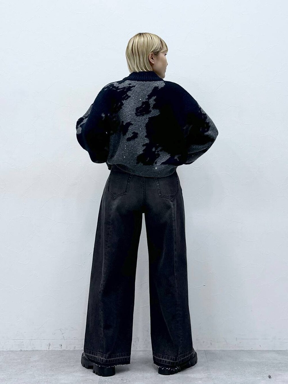 ブラック系のデニムパンツ、ブラック系のニット/セーター、ブラック系のローファーを着用したレディースの冬コーディネートの5枚目の写真