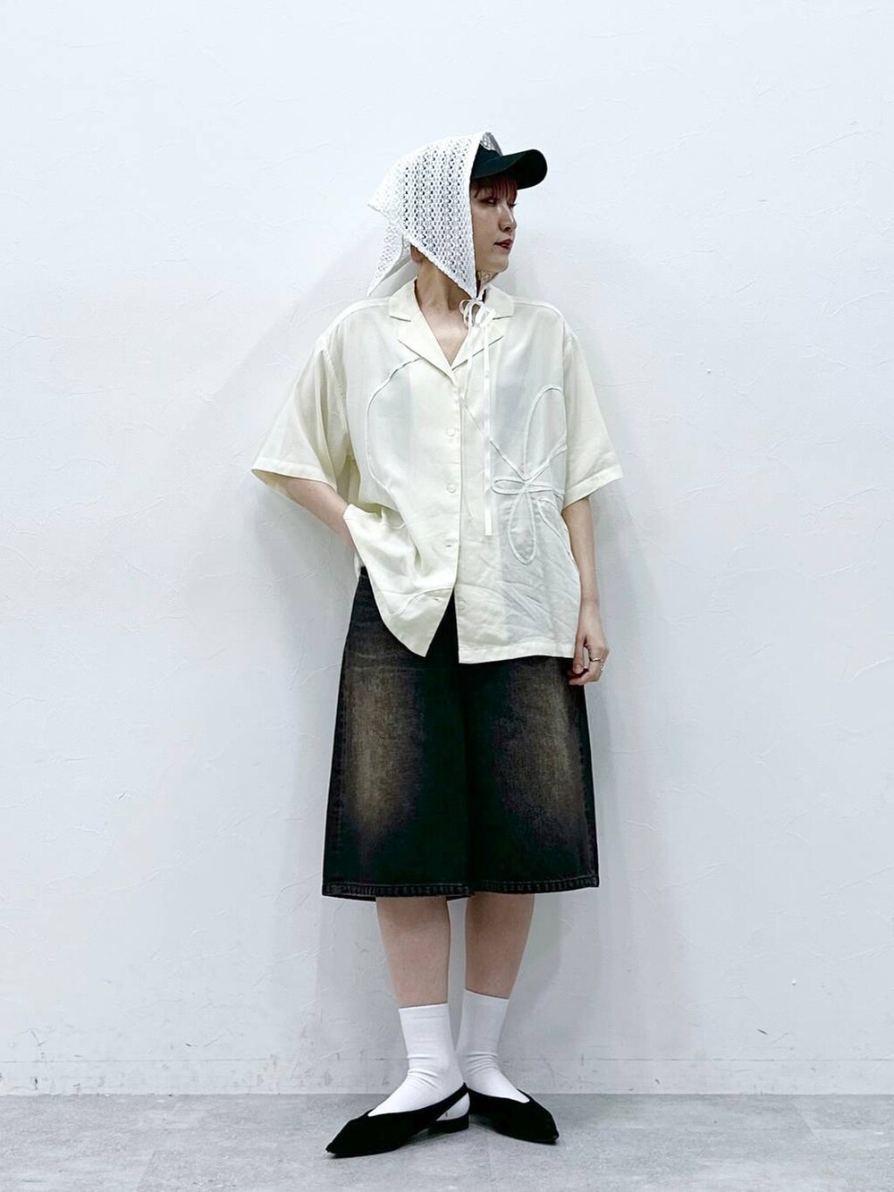 ブラック系のデニムパンツ、ホワイト系のシャツ/ブラウスを着用したレディースの春コーディネートの2枚目の写真
