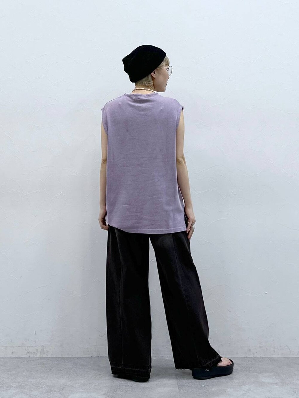 ブラック系のデニムパンツ、パープル系のTシャツ/カットソー、ブラック系のサンダルを着用したレディースの夏コーディネートの7枚目の写真