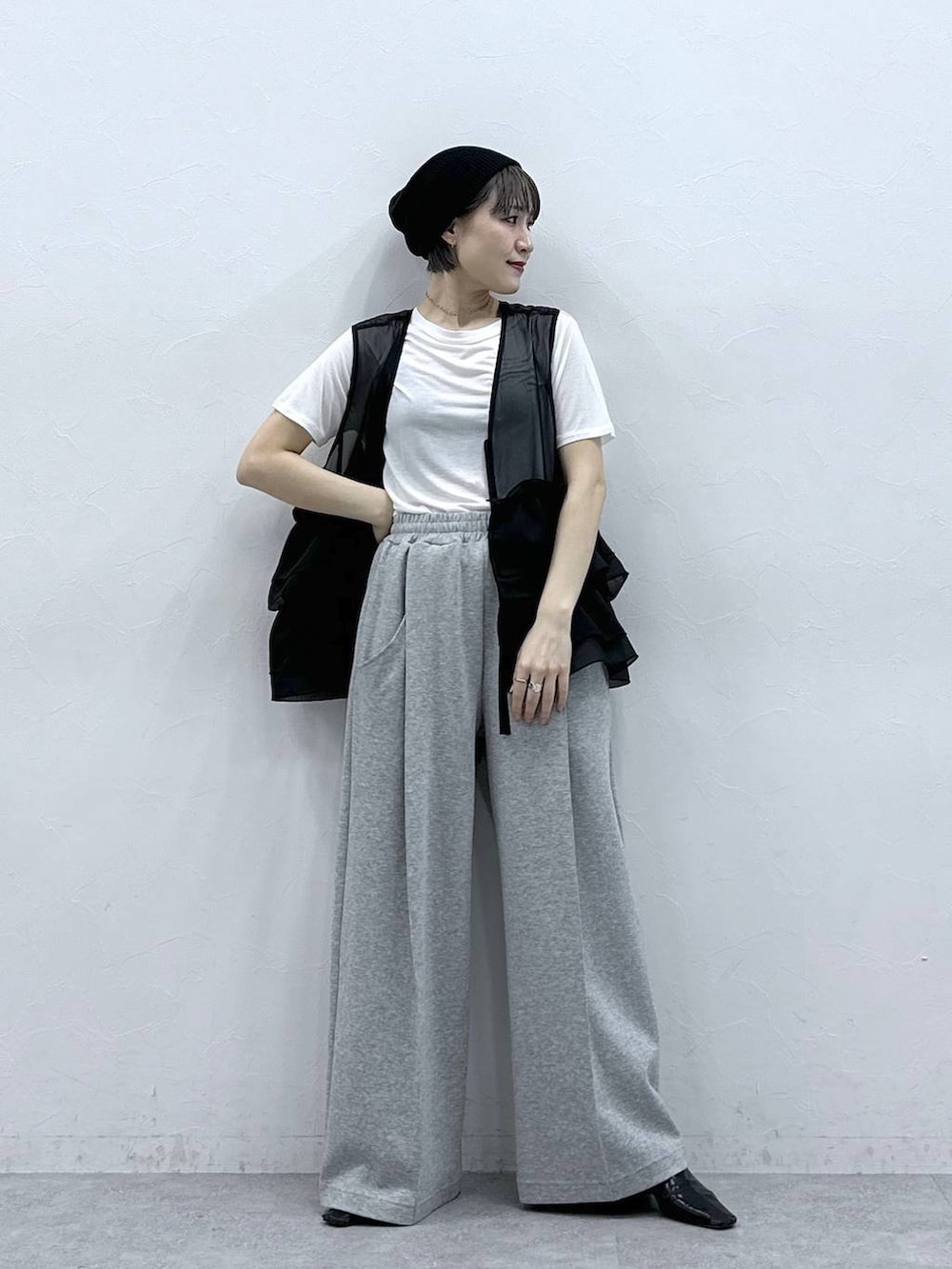グレー系のスウェットパンツ、ホワイト系のTシャツ/カットソー、ブラック系のベストを着用したレディースの春コーディネートの4枚目の写真