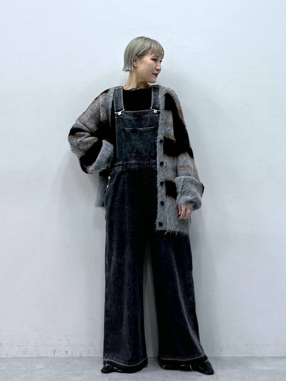 ブラック系のTシャツ/カットソー、ブラック系のカーディガン/ボレロ、ブラック系のサロペット/オーバーオールを着用したレディースの秋コーディネートの5枚目の写真