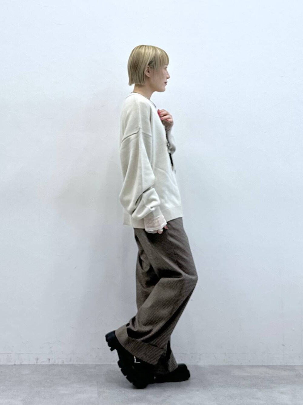 ホワイト系のニット/セーター、ブラック系のローファー、ブラウン系のスラックスを着用したレディースの秋コーディネートの4枚目の写真