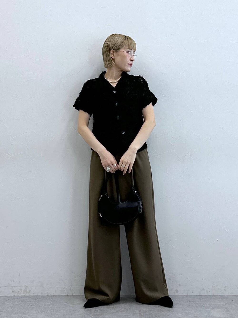 ブラック系のシャツ/ブラウス、ブラウン系のスラックスを着用したレディースの夏コーディネートの2枚目の写真