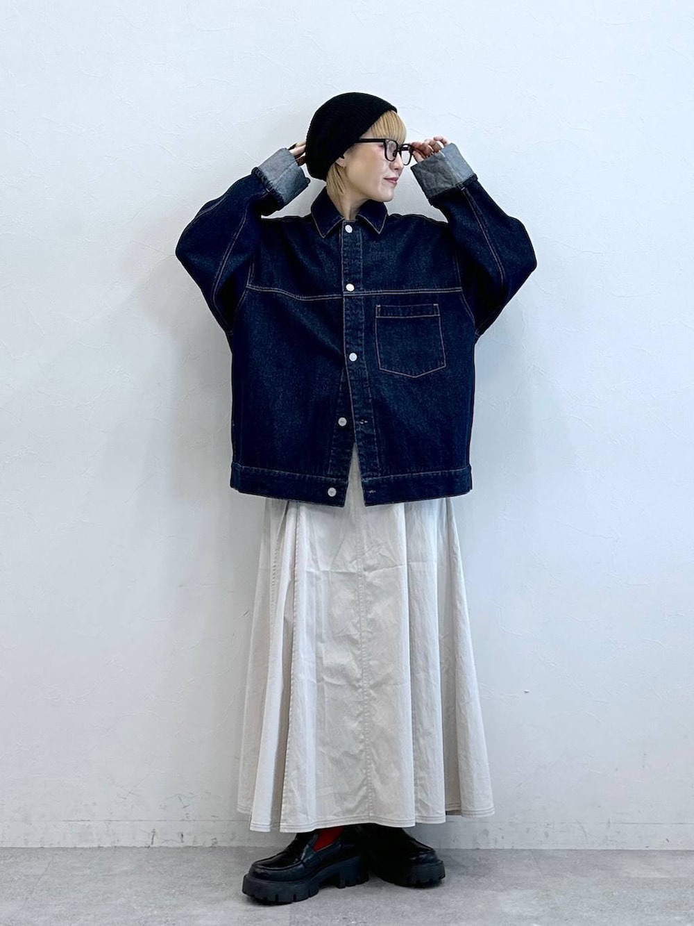 ブラック系のローファー、ブルー系のデニムジャケット、ホワイト系のスカートを着用したレディースの夏コーディネートの3枚目の写真
