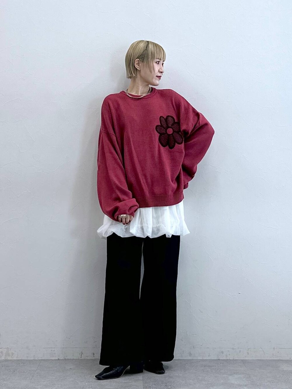 ブラック系のテーラードジャケット、ピンク系のニット/セーター、ホワイト系のスカートを着用したレディースの秋コーディネートの3枚目の写真