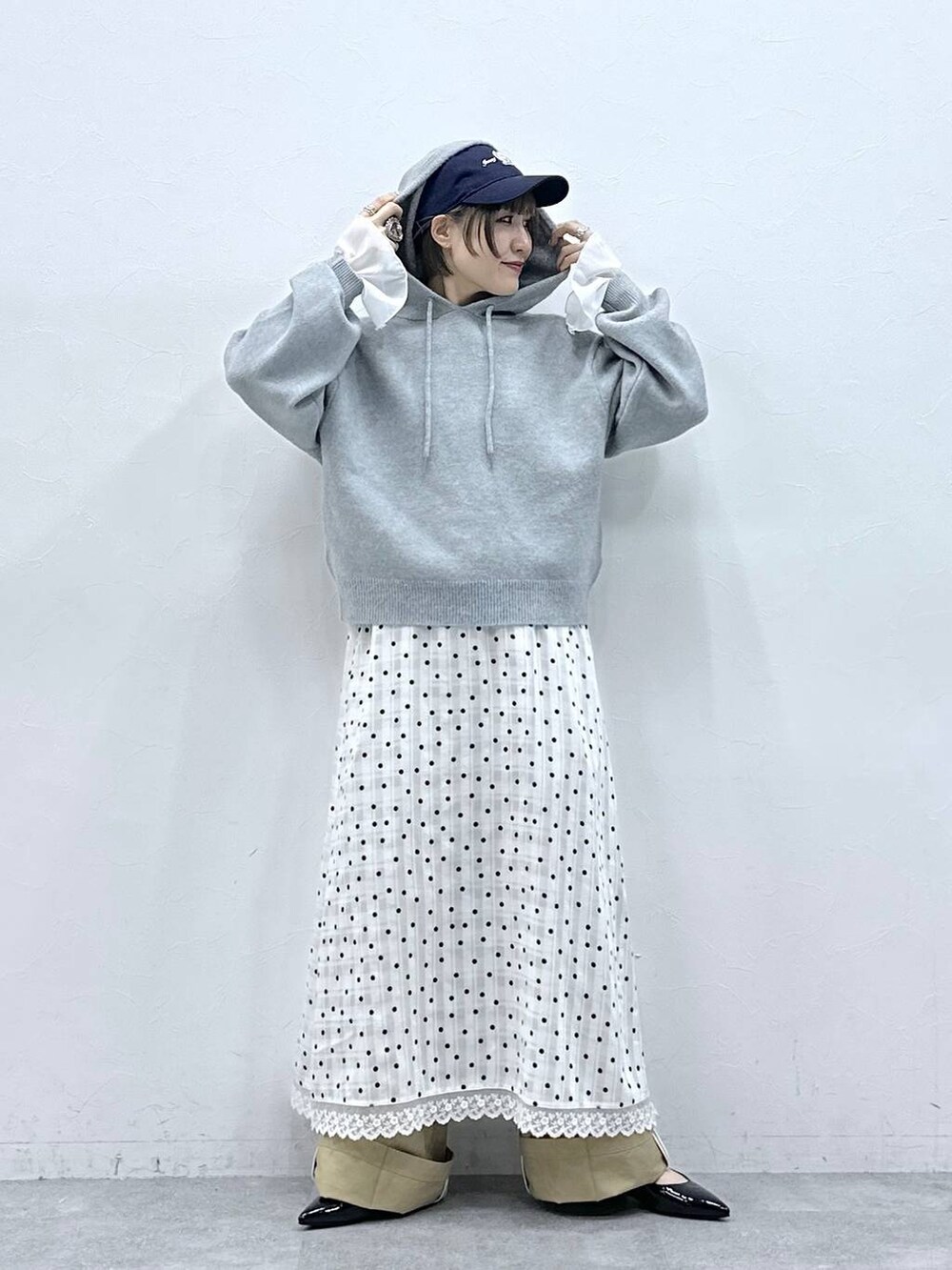 ブラック系のパンプス、グレー系のニット/セーター、ベージュ系のチノパンツを着用したレディースの冬コーディネートの2枚目の写真