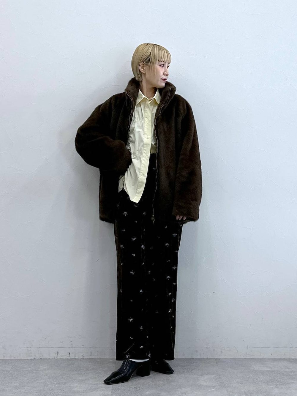 ブラウン系のスウェットパンツ、ブラウン系のブルゾン、イエロー系のシャツ/ブラウスを着用したレディースの秋コーディネートの3枚目の写真