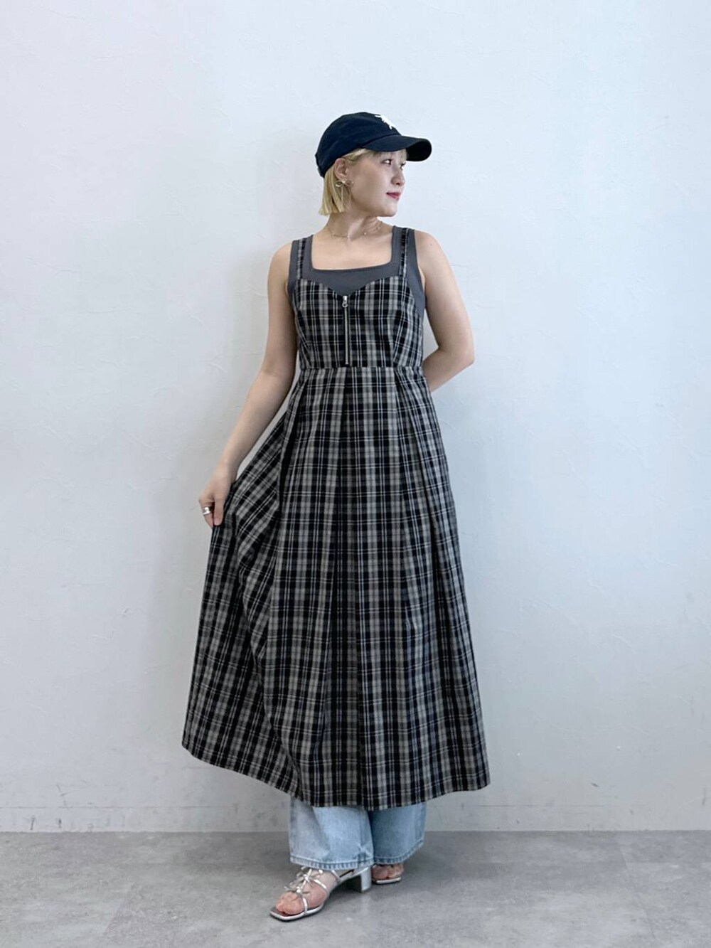 ブラック系のワンピース、シルバー系のサンダル、ブルー系のデニムパンツを着用したレディースの夏コーディネートの2枚目の写真