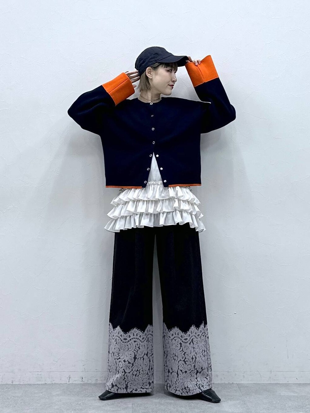 ホワイト系のキャミソール、ブルー系のカーディガン/ボレロ、ブラック系のデニムパンツを着用したレディースの冬コーディネートの4枚目の写真