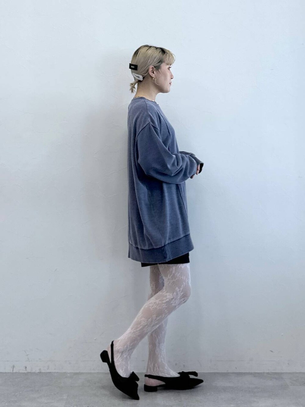 ブラック系のパンプス、ブラック系のチノパンツ、ブルー系のスウェットを着用したレディースの秋コーディネートの5枚目の写真